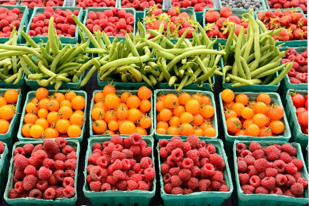A table filled with lots of baskets full of berries.